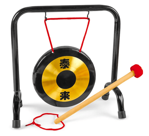 A circular golden gong with a black rim hanging from a stand with a mallet resting on the stand